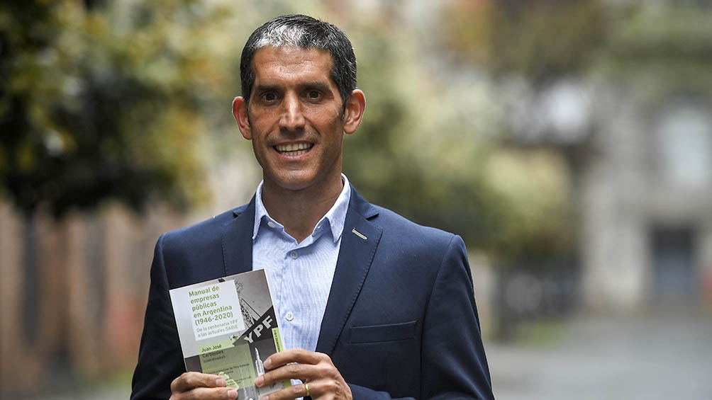 Juan José Carbajales con su obra, a la que se puede acceder de manera libre en la página de la editorial universitaria y que se comercializa a precios populares en su versión en papel.