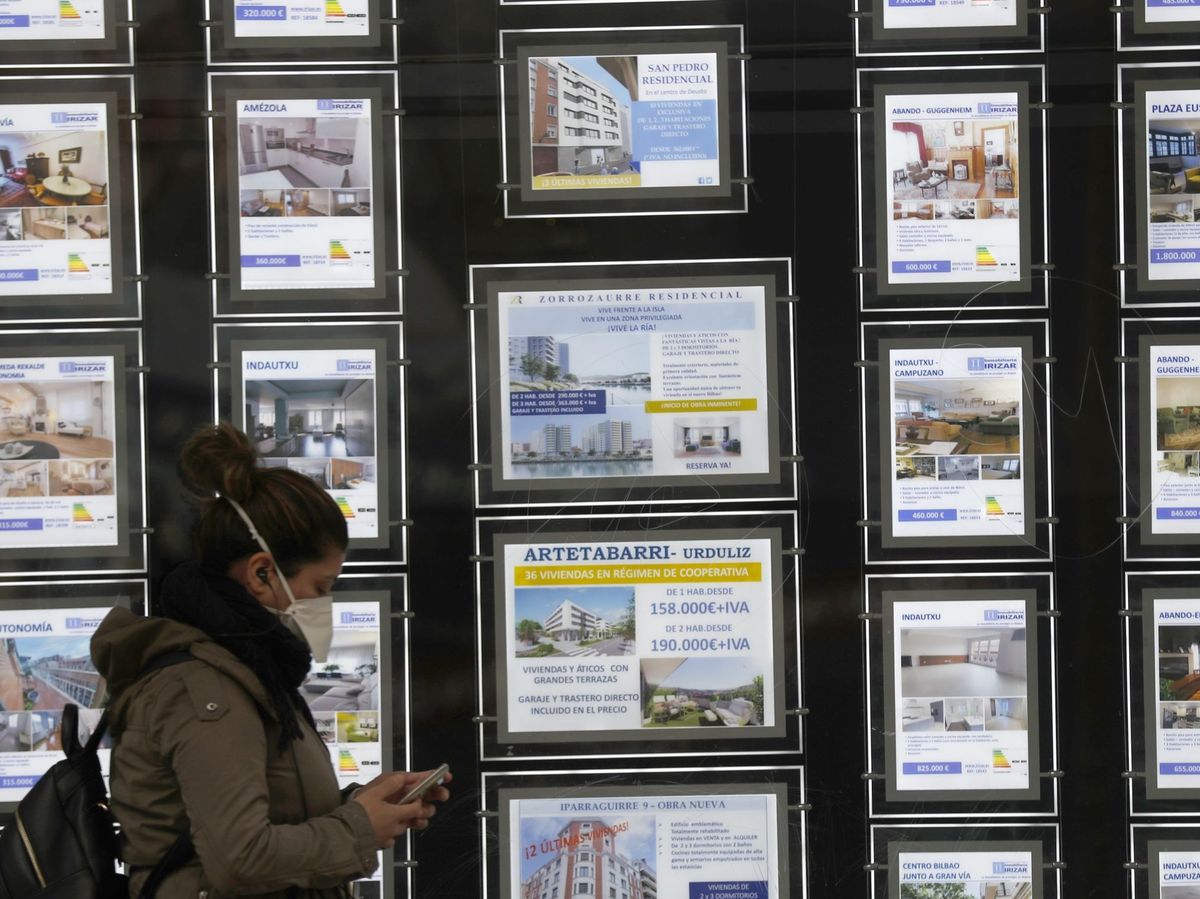 Foto: Una mujer pasa por delante de un portal inmobiliario. (EFE)