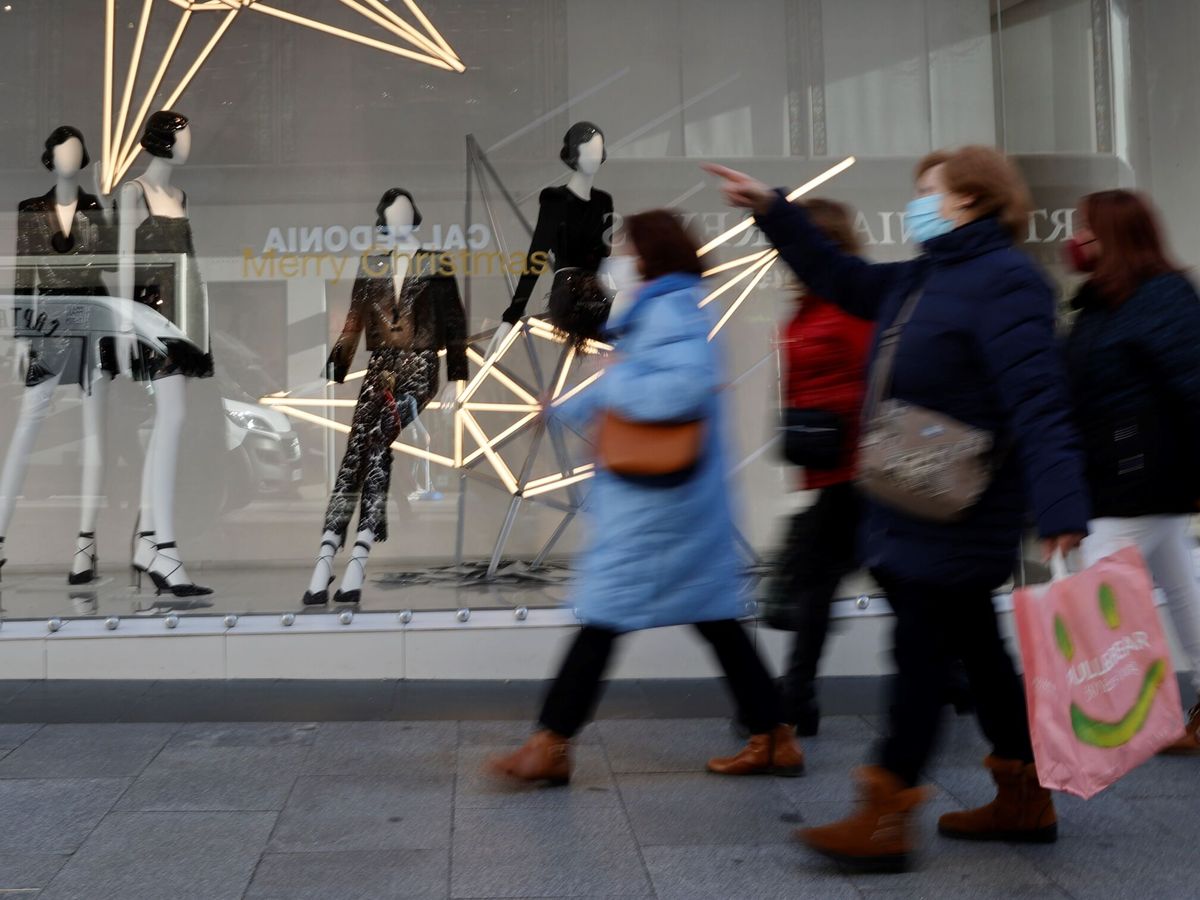 Foto: Varias personas pasan ante un escaparate en Madrid. (EFE/Mariscal)