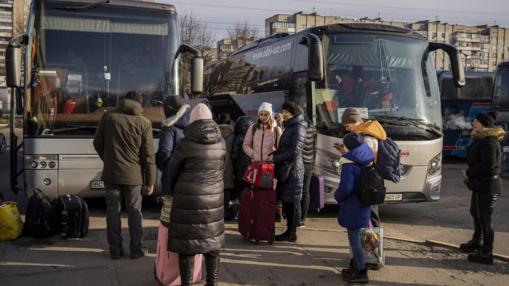 Unos ucranianos se preparan para subir a un autobús con destino a Polonia en la estación central de autobuses de Lviv, en el oeste de Ucrania, el 1 de marzo de 2022 (AP Photo/Bernat Armangue)