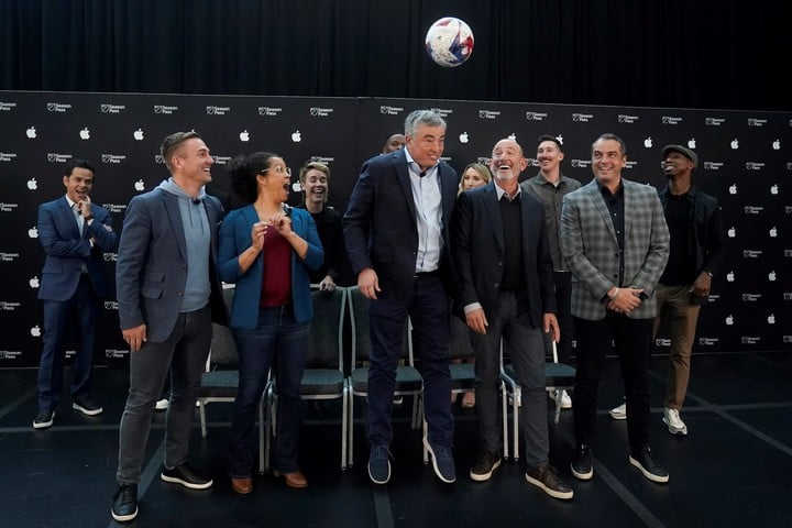 El vicepresidente de servicios de Apple, Eddy Cue, salta para cabecear junto al comisionado de la MLS, Don Garber.