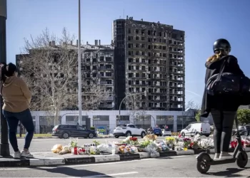Un altar de flores con esqueleto calcinado al fondo en el barrio de Campanar>