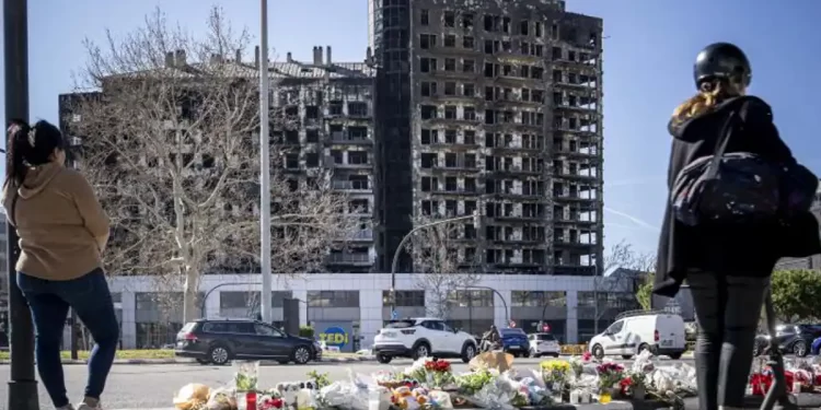 Un altar de flores con esqueleto calcinado al fondo en el barrio de Campanar>