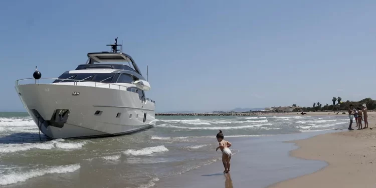 El yate de cinco millones de euros encallado en una playa de Valencia atrae a los turistas: «Señoras, bájense del barco»>